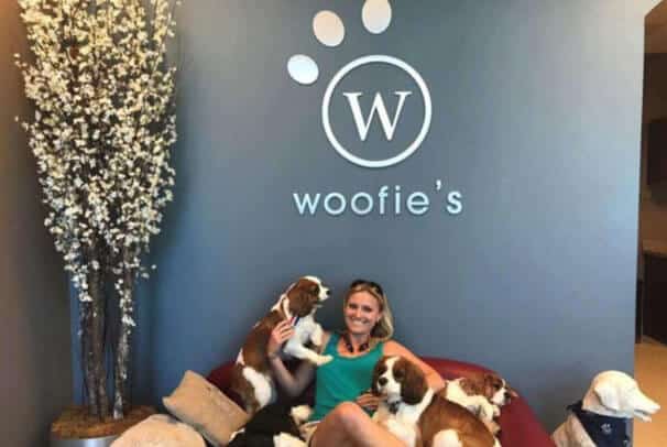 Own a woofies franchise owner sitting in a couch with her pets