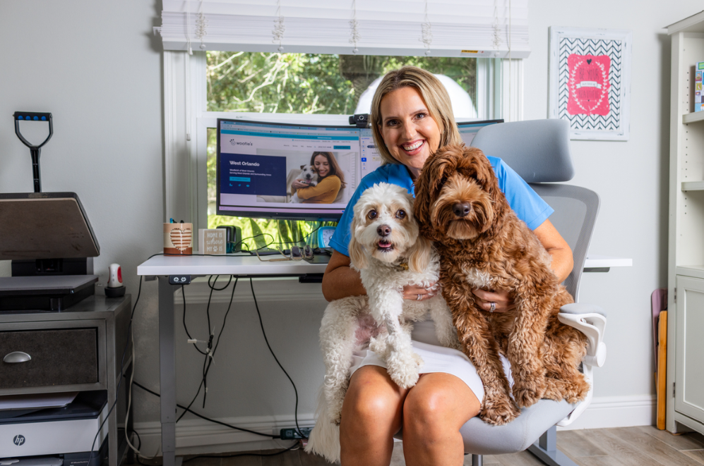 women sitting in chair holding two dogs